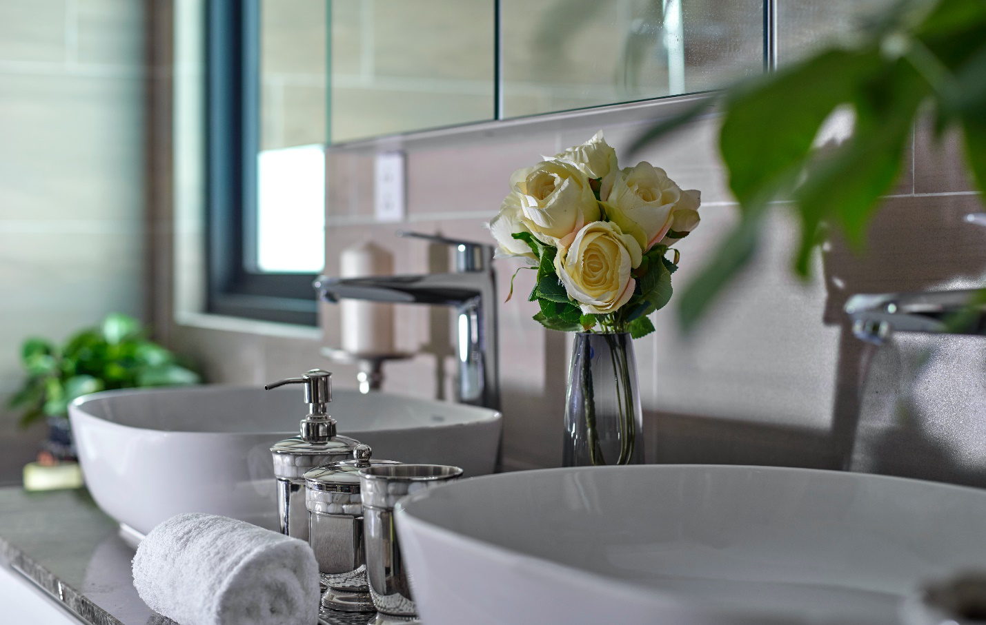 A vase of roses rests atop a bathroom vanity top
