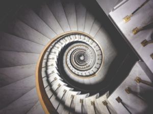A grand marble staircase spirals down a building