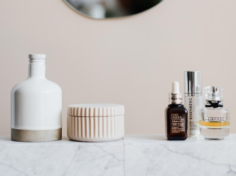 A marble shelf holds cosmetic products