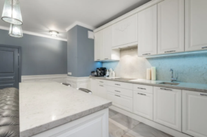 kitchen with white cabinetry, marble countertops, and soft blue walls