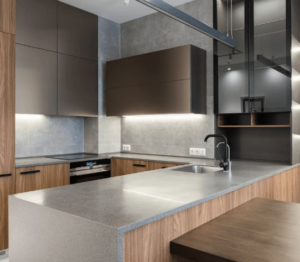 A modern kitchen countertop with a smooth, light-colored surface.