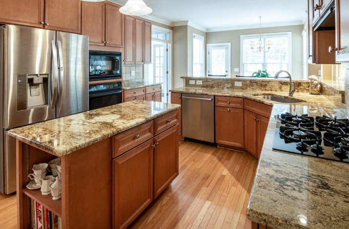 A kitchen island with a speckled quartz countertop.