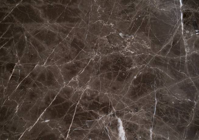 A close-up of a dark brown marble slab with intricate white veining.