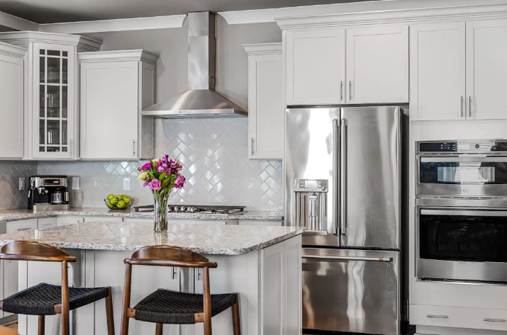A modern kitchen island with a light-colored granite countertop 